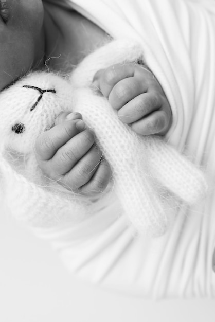 Foto sonho de um recém-nascido nos primeiros dias de vida retrato de um bebê de uma semana de idade com um bonito coelho de pelúcia de brinquedo mole dentes e mãos bonitas de uma criança foto em branco e preto