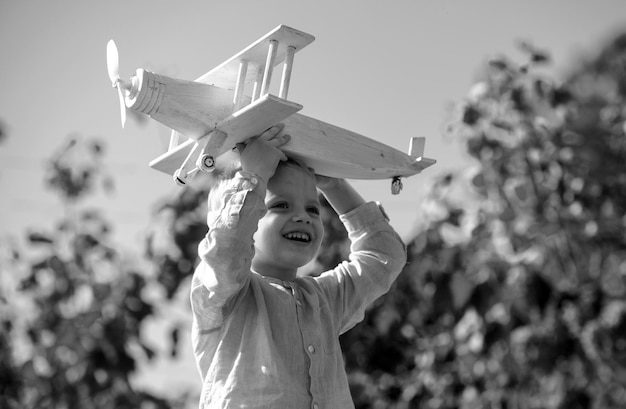 Sonhos de voo criança brincando com avião de brinquedo contra o céu sonhos de viagens pouco sonhando