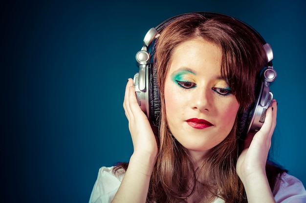 Sonido, joven escuchando música con enormes auriculares.