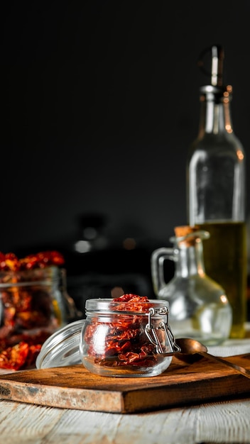 Sonnen getrocknete Tomaten in einem Glas auf einem Schneidbrett