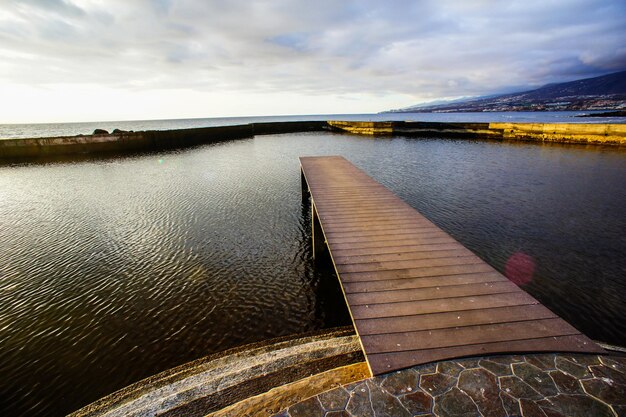 Sonnenaufgang auf einem Pier über dem Atlantischen Ozean in Teneriffa-Kanarische Inseln-Spanien