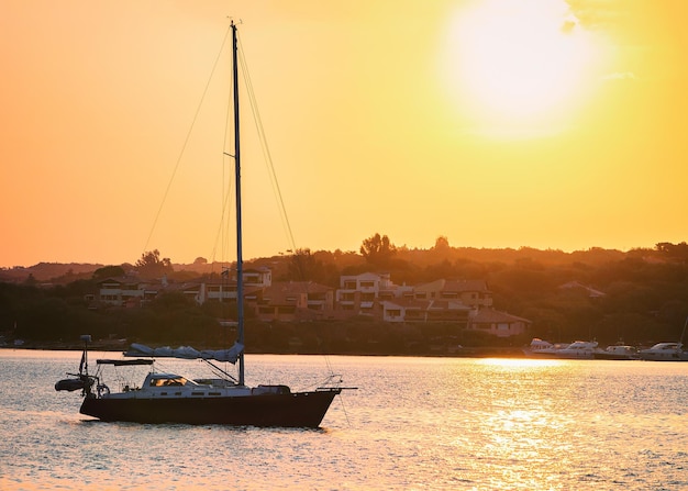 Sonnenaufgang mit Boot an der Costa Smeralda am Mittelmeer, Sardinien, Italien