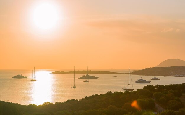 Sonnenaufgang mit Yachten und Schiffen in Porto Rotondo an der Costa Smeralda am Mittelmeer, Sardinien, Italien