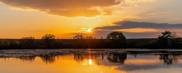 Sonnenaufgang oder Sonnenuntergang am Fluss Reflexion des Himmels und der Wolken im Flusswasser