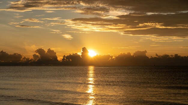 Sonnenaufgang schoss über das Meer und schöne Wolke. Die Sonne verschwand hinter einer großen Wolke über dem Ozean.