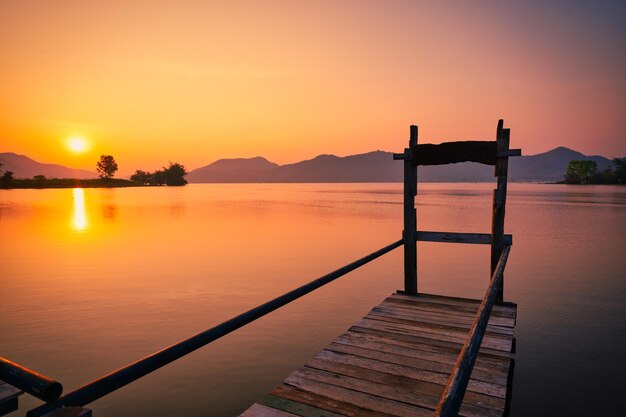 Sonnenaufgang über Berg und See mit Holzsteg