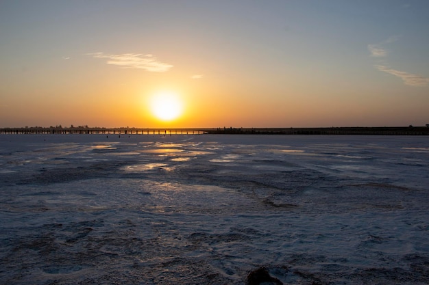 Sonnenaufgang über dem rosafarbenen See und den Salzufern die Reflexion der Sonnenstrahlen auf der Spiegeloberfläche der Salzoberfläche