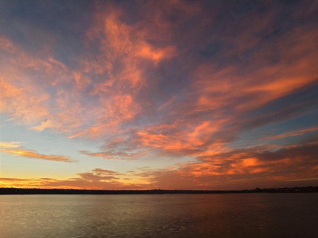 Sonnenaufgang über dem See mit rotorangen Wolken