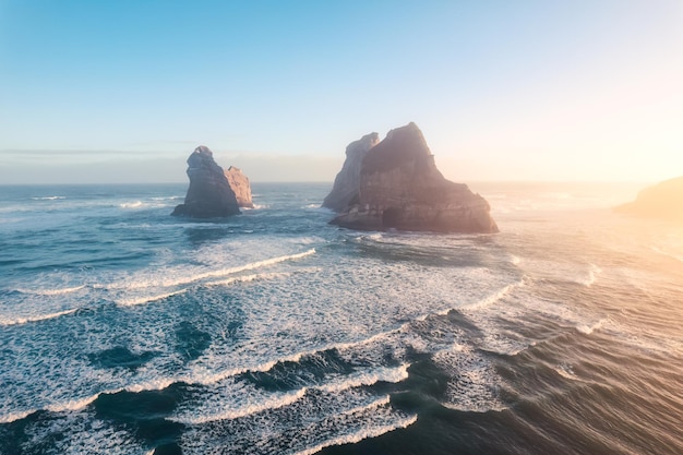 Sonnenaufgang über dem Wharariki-Strand und den Archway-Inseln im Tasman-Meer am Cape Farewell, Neuseeland