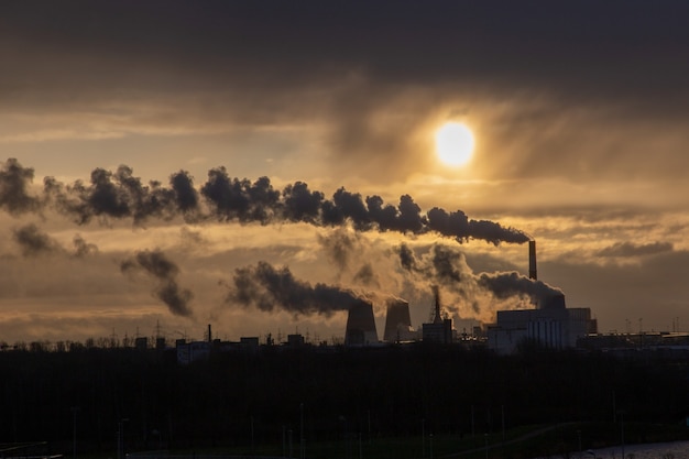 Sonnenaufgang über rauchenden Schornsteinen Heizkraftwerk