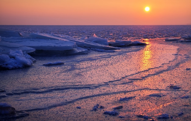 Sonnenaufgang und gefrorenes Meer. Schöne Winterlandschaft mit See in der Morgenzeit. Tagesanbruch