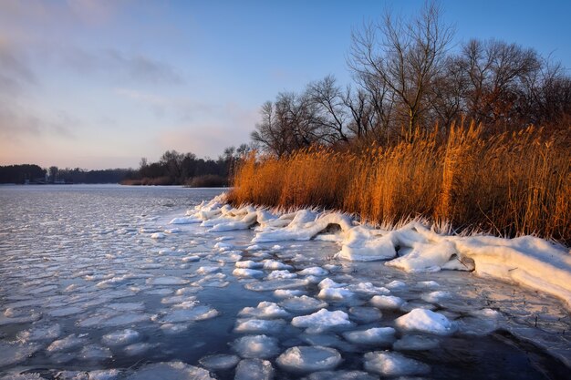 Sonnenaufgang und gefrorenes Meer. Schöne Winterlandschaft mit See in der Morgenzeit.