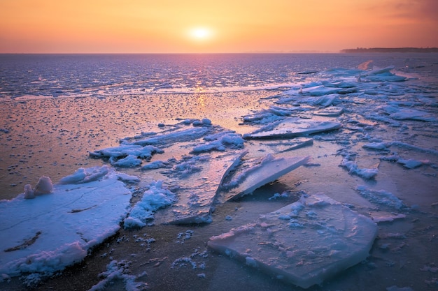 Sonnenaufgang und gefrorenes Meer Schöne Winterlandschaft mit See und roter Sonne in der Morgenzeit Tagesanbruch