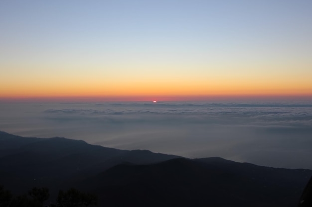 Sonnenaufgang von den Bergen aus gesehen Sonne am Horizont über den Wolken