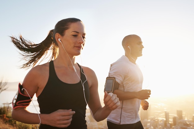 Sonnenaufgangs-Streaming und Fitness-Paar laufen als Workout oder Morgengymnastik für Gesundheit und Wohlbefinden gemeinsam Sportmarathon und Läuferin läuft mit Sportlerin zum Training für Sport oder Energie