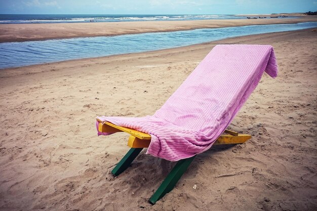 Sonnenbett in Handtuch gewickelt am Strand