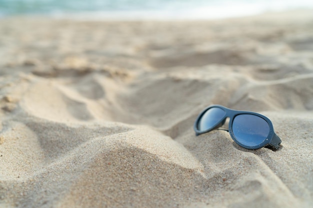 Sonnenbrille am Strand für Urlaubskonzept oder Sommerhintergrund