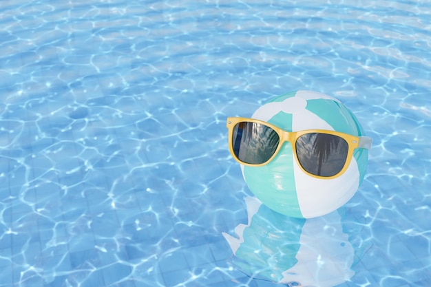 Sonnenbrille auf aufblasbarem Ball im Schwimmbad