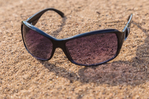 Sonnenbrille auf dem Strandsand