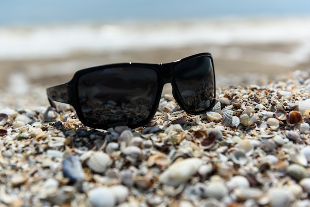 Sonnenbrille liegt im Sand am Meer sea