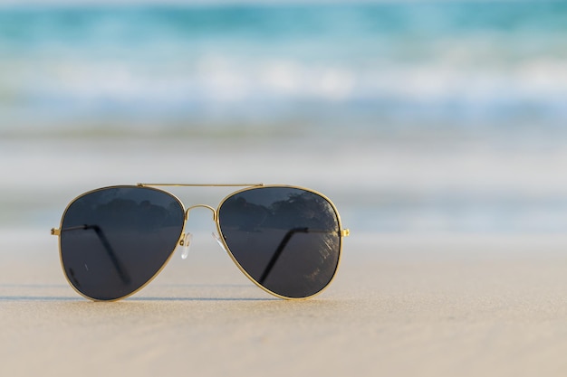 Sonnenbrillen auf Sand schönen Sommerstrand kopieren Raum Urlaubskonzept.