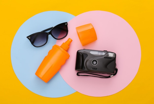 Sonnencreme-Flasche, Sonnenbrille und Kamera