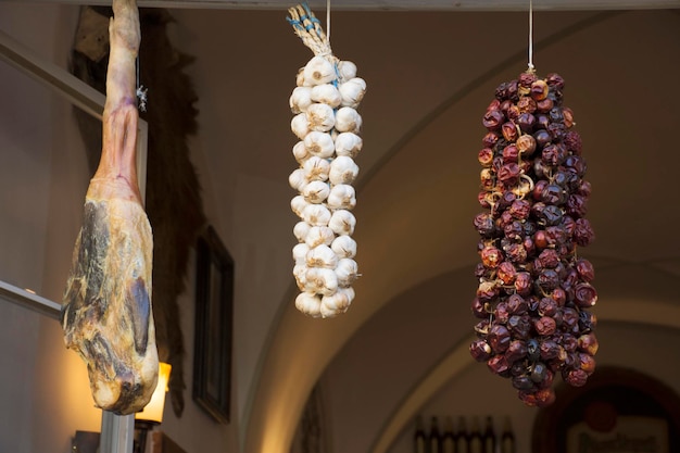 Sonnengetrocknete Schweinekeule und Knoblauch und Gewürze hängen am Fenster des Restaurants in der Stadt Prag für Show- und Verkaufsleute und Reisende in Prag in der Tschechischen Republik