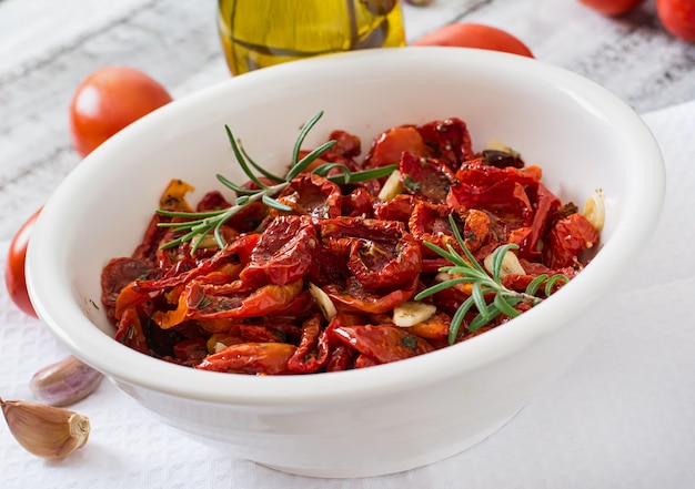 Sonnengetrocknete Tomaten mit Kräutern und Knoblauch in einer Holzschale