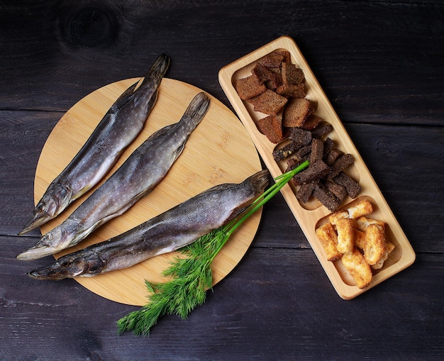 Foto sonnengetrockneter fisch gesalzene stints über holzhintergrund draufsicht kopierbereich snack für biergetrocknete stints