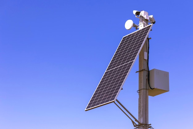 Sonnenkollektor mit cctv Cameraon Säule auf Himmelshintergrund. Überwachungskamera mit Mini-Solarpanel