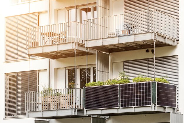 Sonnenkollektoren auf dem Balkon des Mehrfamilienhauses. Moderner Balkon mit Sonnenkollektorsystem und Fensterläden