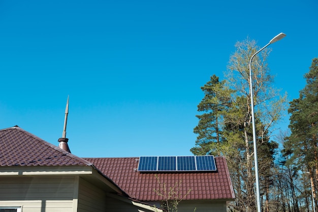 Sonnenkollektoren auf dem Dach eines einstöckigen Privathauses auf dem Land Umweltfreundliche Nutzung von Sonnenenergie als alternative Quelle Schonung der Naturressourcen