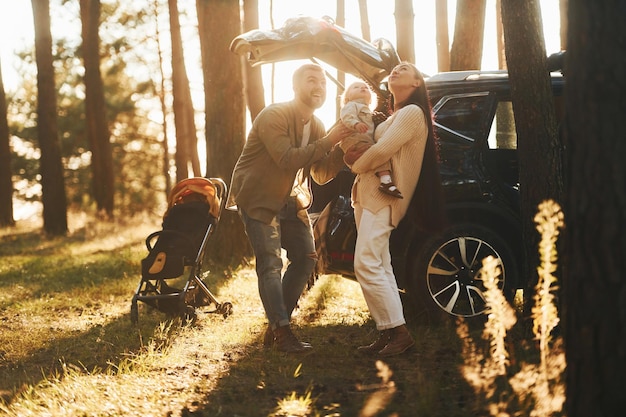 Sonnenlicht im Hintergrund Glückliche Familie von Vater, Mutter und kleiner Tochter ist im Wald