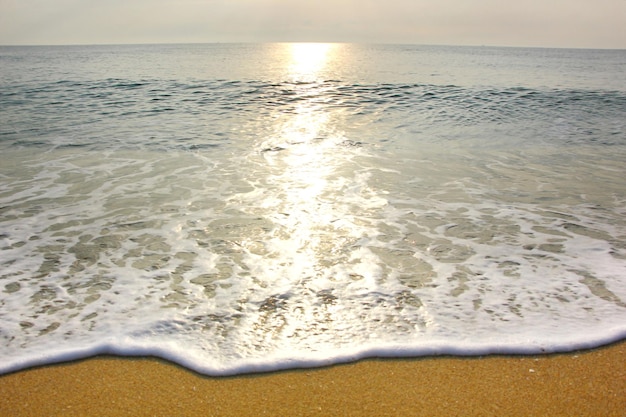 Sonnenlichteinfluss auf Welle kommt am Strand