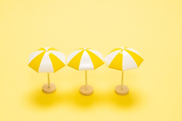 Sonnenliege und gelber Regenschirm auf gelb.