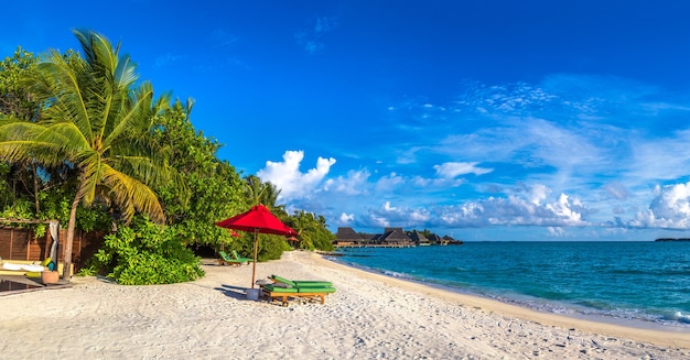 Sonnenliege und Sonnenschirm am tropischen Strand auf den Malediven