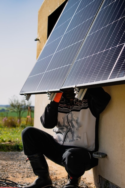 Sonnenpaneele an einer gut exponierten Wand eines einzelnen Hauses, die nach der Energiekrise Einsparungen erzielen. Öko-Bürger-Geste grüne Energie