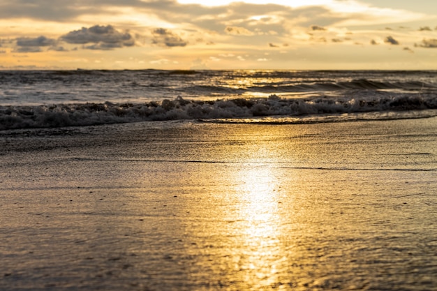 Sonnenreflexion am Meeresstrand mit dem flachen Fokus am Abend