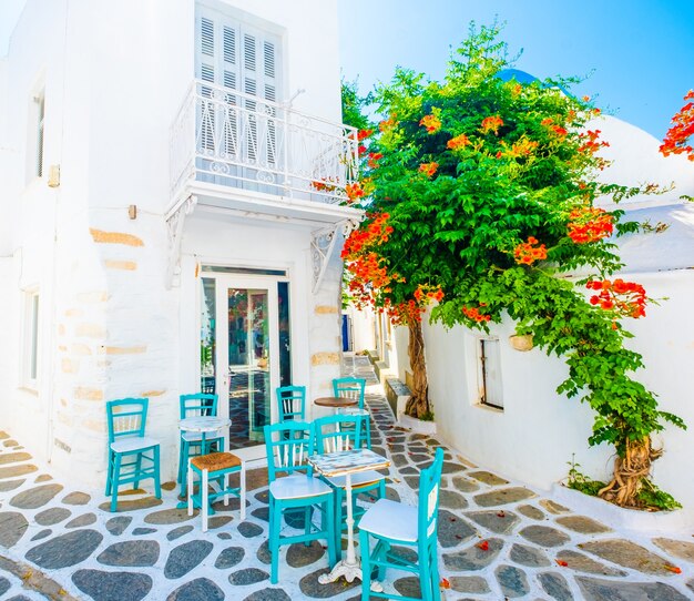 Sonnenschein mit Blick auf das Restaurant und grüne Bäume mit weißer Architektur der griechischen Straße