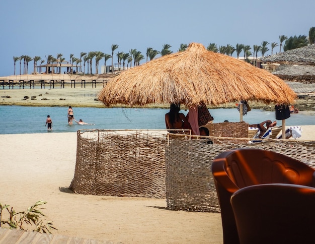 Sonnenschirm am Sandstrand mit Palmen in Ägypten