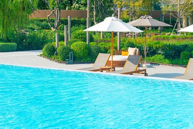Sonnenschirm mit Bettpool rund um den Pool mit Ozean-Meer-Hintergrund - Urlaubs- und Urlaubskonzept