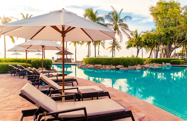 Sonnenschirm und Stuhl um den Pool im Resorthotel für Urlaubsreisen und Urlaub in der Nähe des Meeres