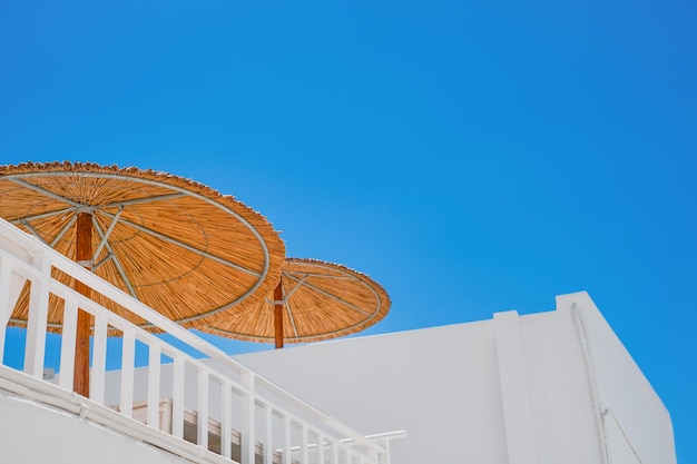 Sonnenschirme auf dem Dach des Hauses gegen den blauen Himmel die griechische Straße im Einkaufszentrum in Lindos Rhodos Insel die griechischen Inseln des Dodekanes-Archipels Europa