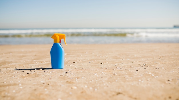 Sonnenschutz- und Sonnencremekosmetikflasche auf Sand am Strand