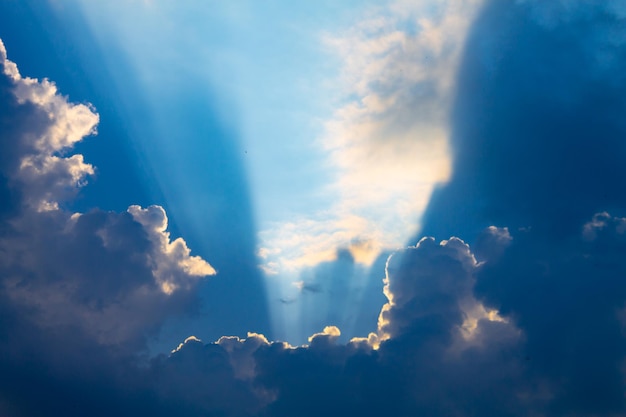 Sonnenstrahlen an einem bewölkten Tag oder Strahlen, die aus Wolken an einem blauen Himmel ausbrechen Spiritueller und religiöser Hintergrund