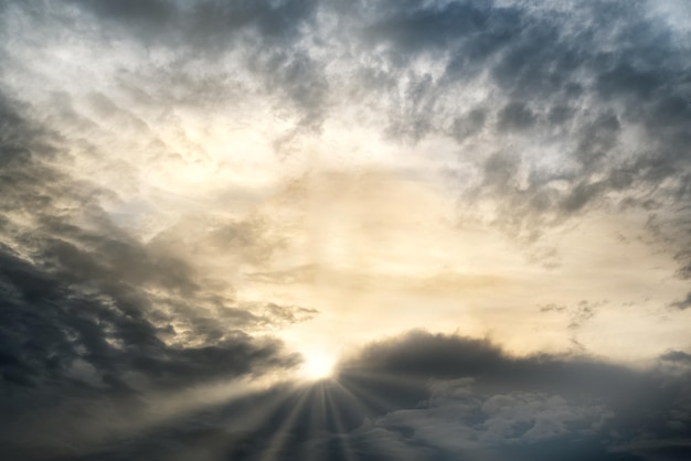 Sonnenstrahlen brechen durch die dichten Gewitterwolken am Abendhimmel