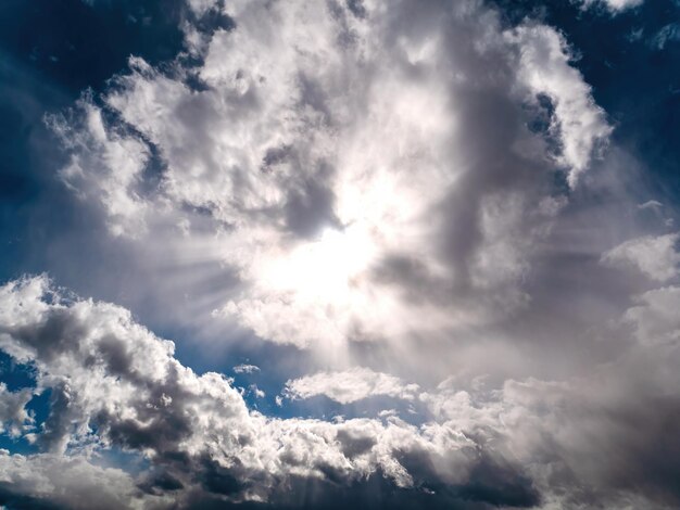 Sonnenstrahlen scheinen durch die Wolken am blauen Himmel