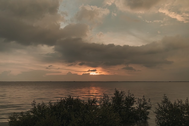 Sonnenuntergang am Meer mit stürmischer Wolke am Himmel