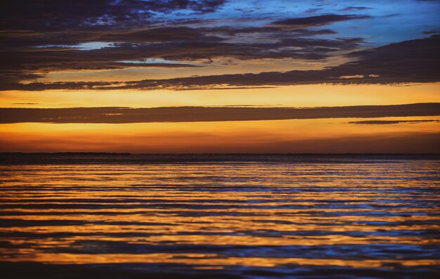 Sonnenuntergang am Meer Strand heller Sonnenuntergang mit großer gelber Sonne unter der Meeresoberfläche