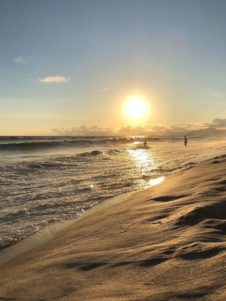 Foto sonnenuntergang am strand barra da tijuca in rio de janeiro, brasilien. meer mit ruhigen wellen.